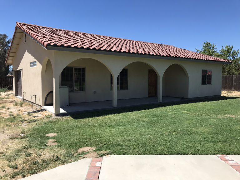 A tan house with a tan roof.