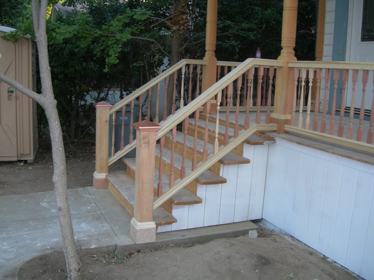A wooden railing on a porch.