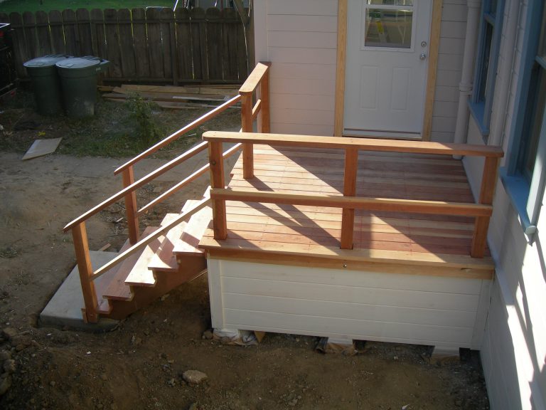 A wooden railing on the side of a house.