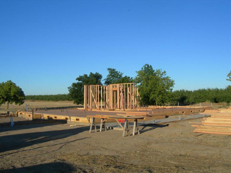 A house being built on a dirt lot.