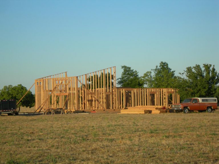 A house being built in a field.