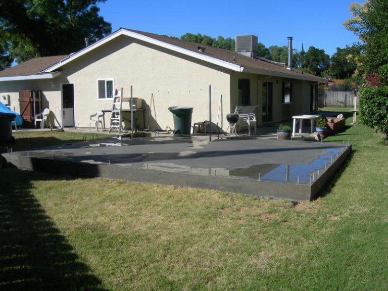 A backyard with a concrete patio.