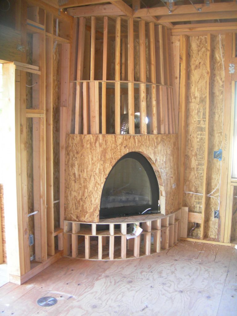 A fireplace in a room that is under construction.