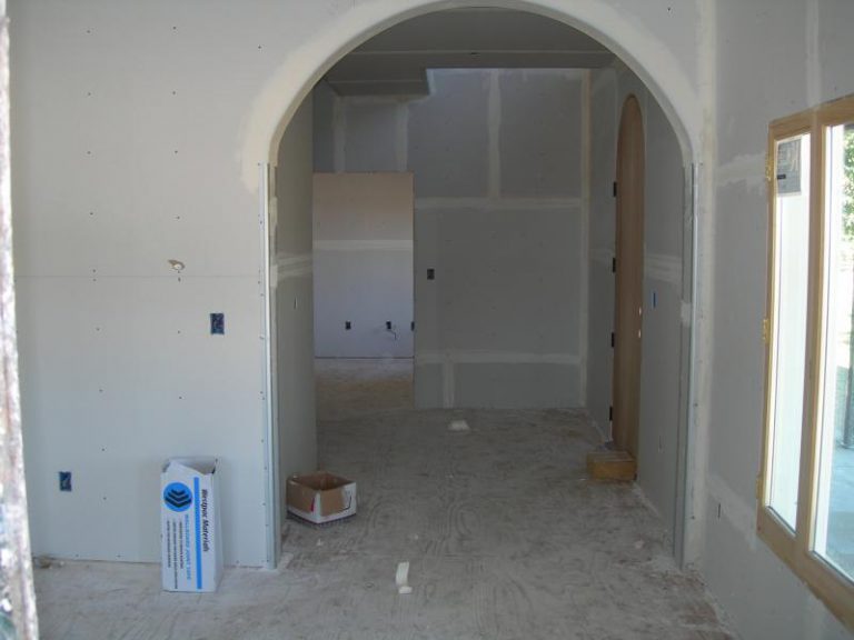 A room that is being remodeled with white walls and a doorway.