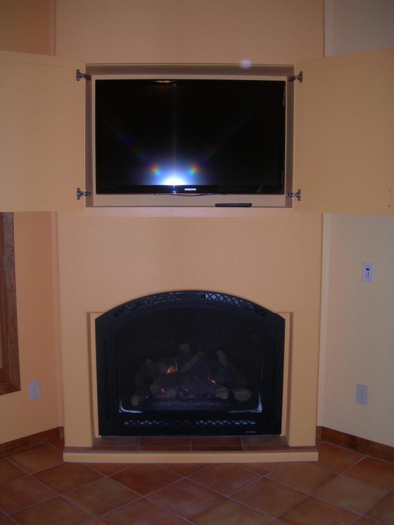 A fireplace with a tv above it.