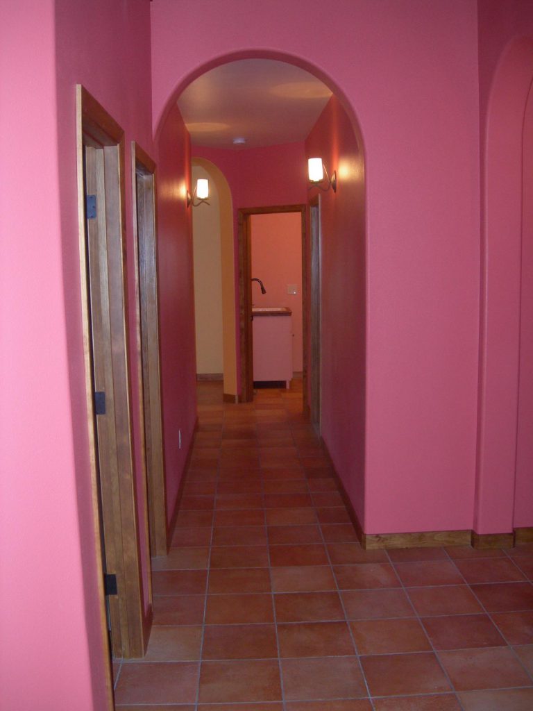 A hallway with a pink wall.