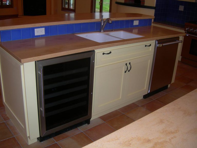 A kitchen with a sink and a refrigerator.