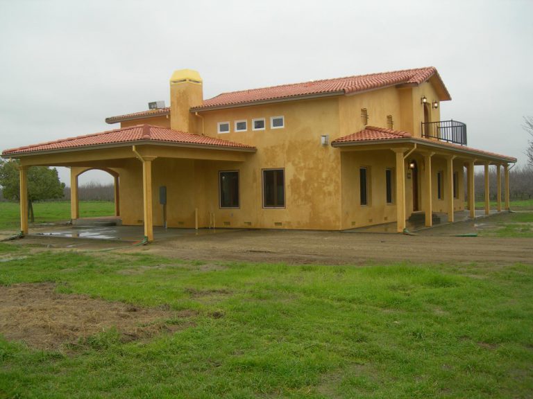 A tan house with a red roof.