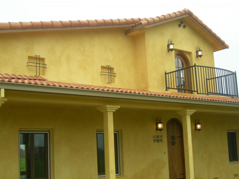 A yellow house with a balcony.