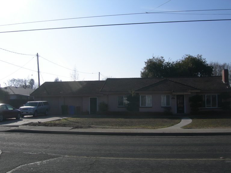 A pink house on a street.