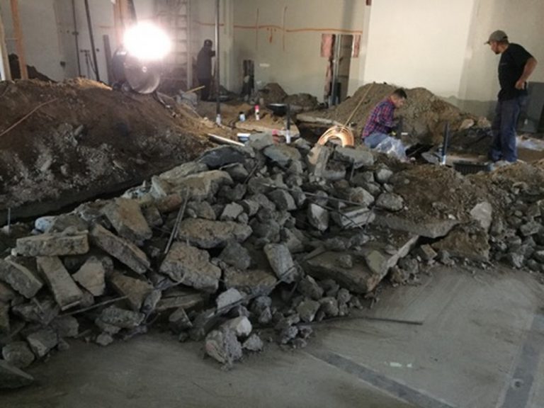 A group of people working on a pile of rubble in a room.
