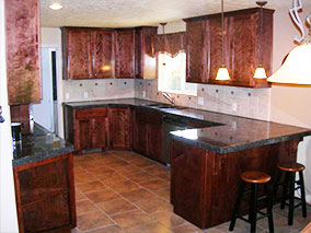 A kitchen with brown cabinets and counter tops.