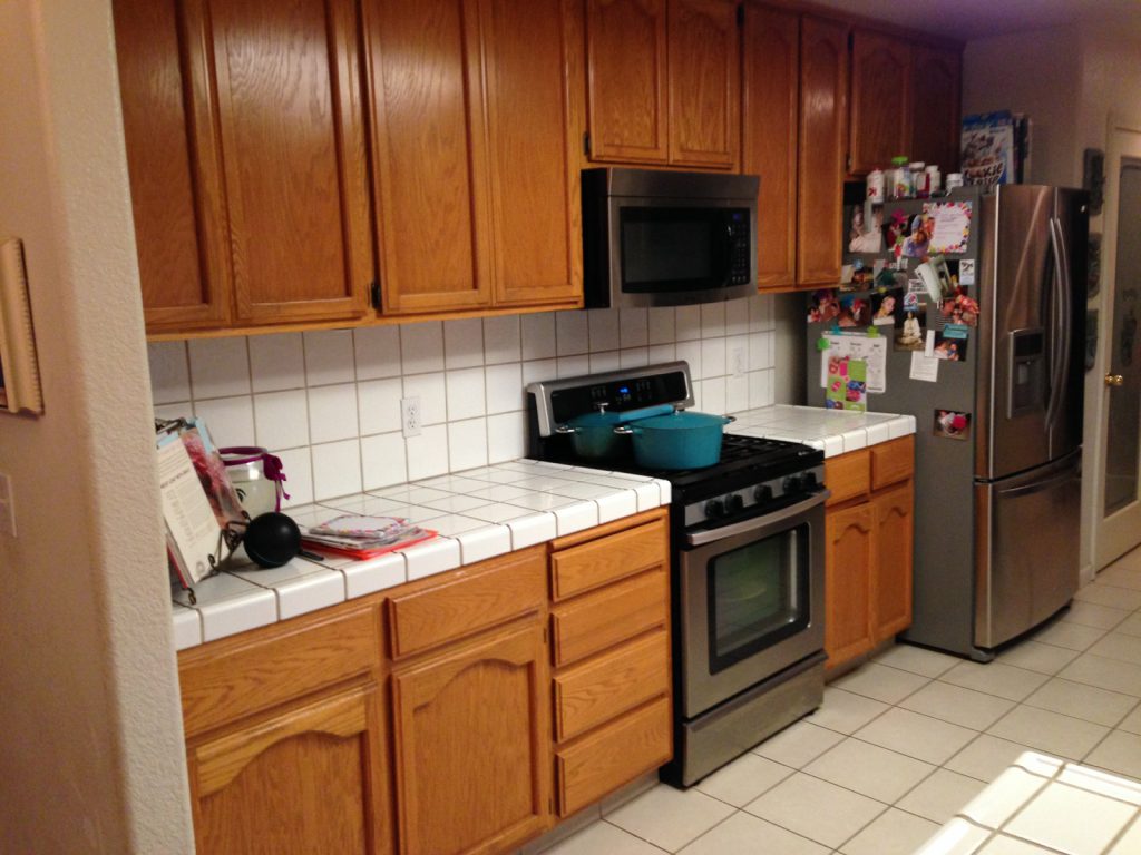 A kitchen with a stove and refrigerator.