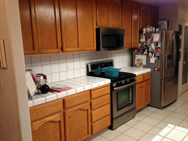 A kitchen with a stove and refrigerator.
