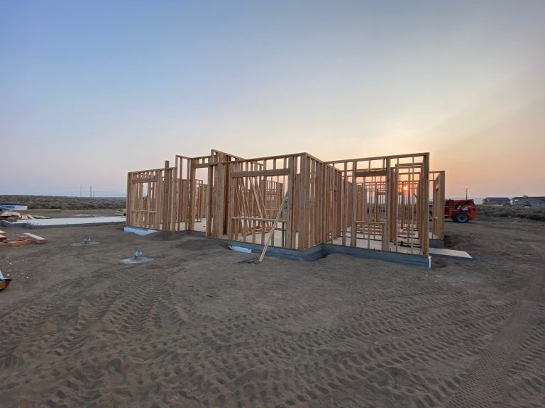 A house under construction with wood framing in the background.